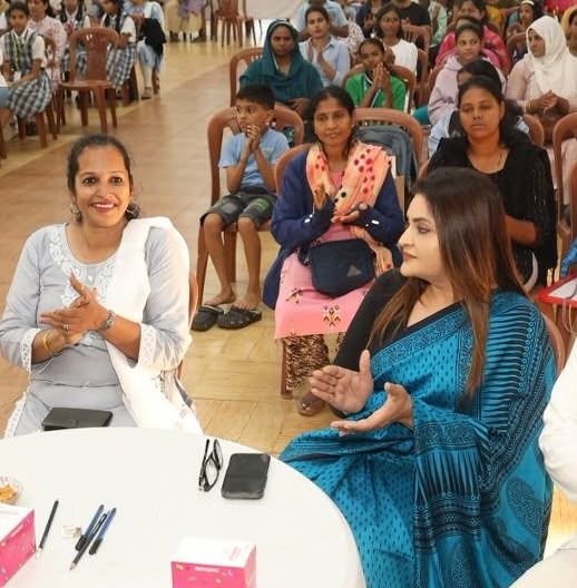 Women and children seated at an awareness session in a community hall